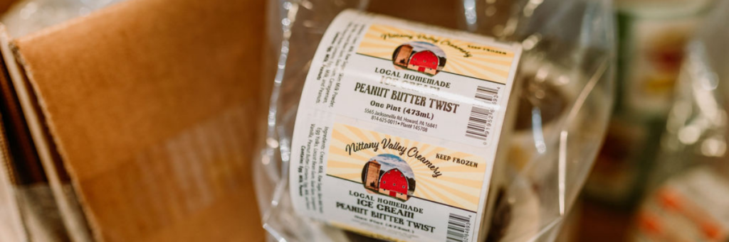 Roll of product labels for peanut butter wist ice cream with shipping boxes in the background