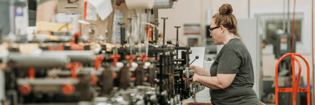 A woman at a machine in a print shop that offers professional printing