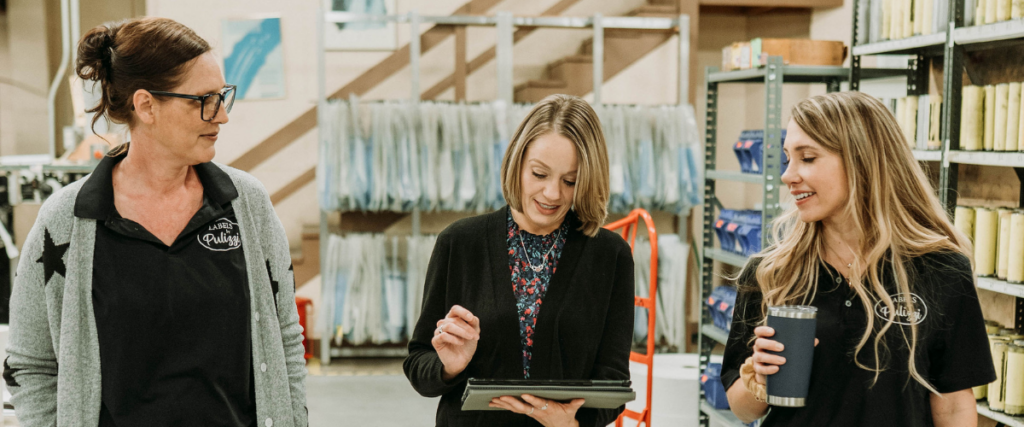 Team reviewing custom beer label printing and quality control process in a production facility